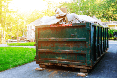 Dumpster full of trash sitting in driveway