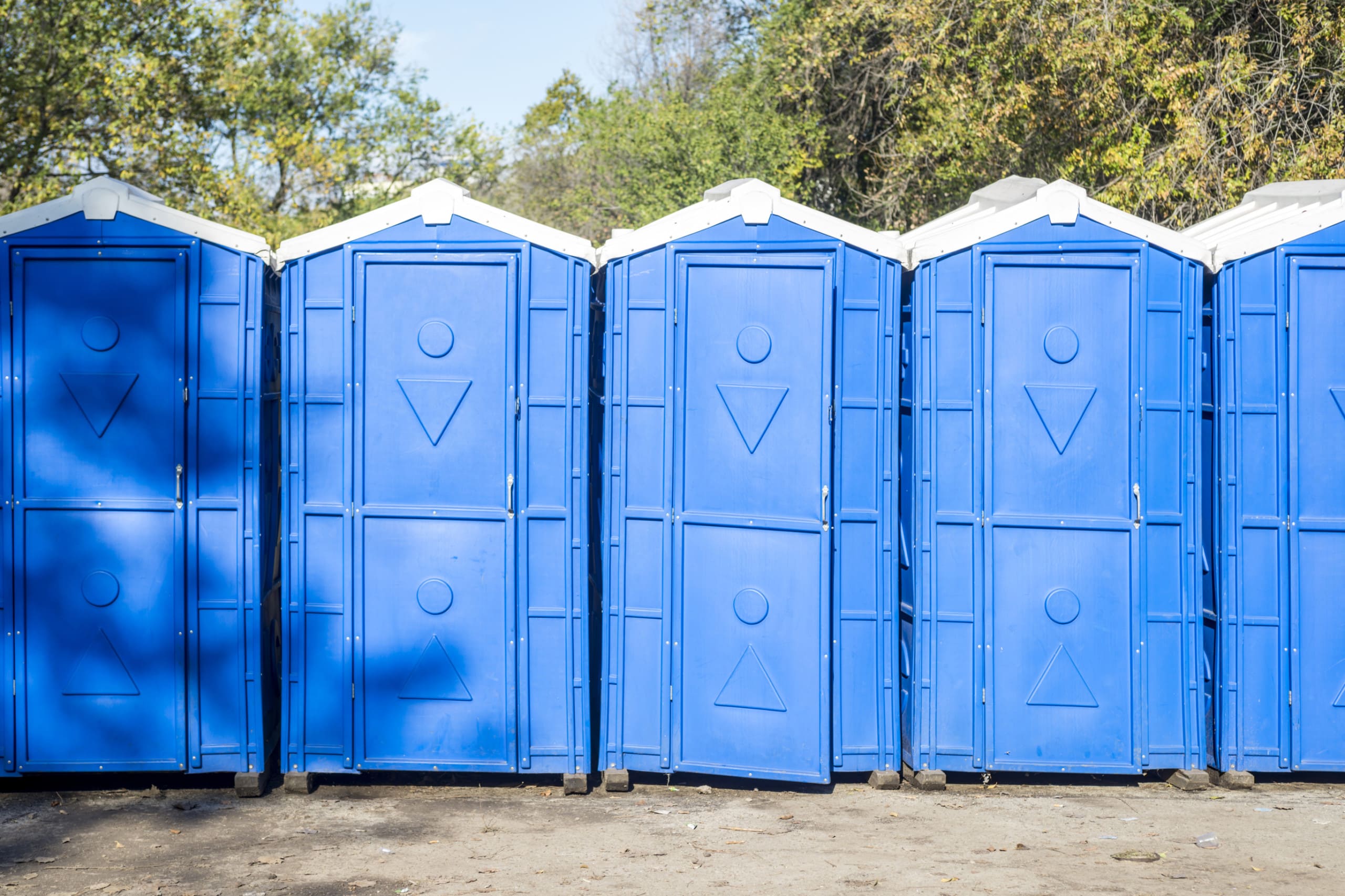 Long row of portable bio toilet cabins. Blue cabines of bio toilets. A large number of street toilets